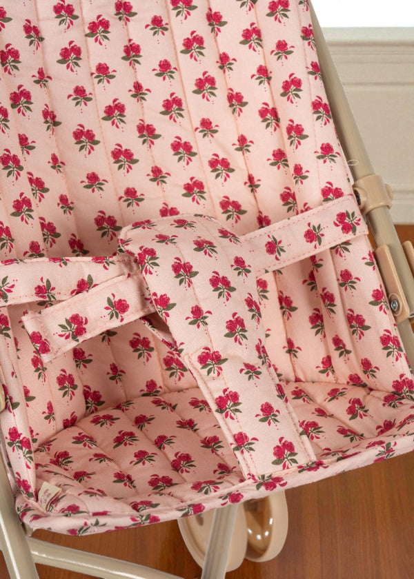 Secure fabric harness system in coordinating rose print ensuring safe doll positioning during stroller play