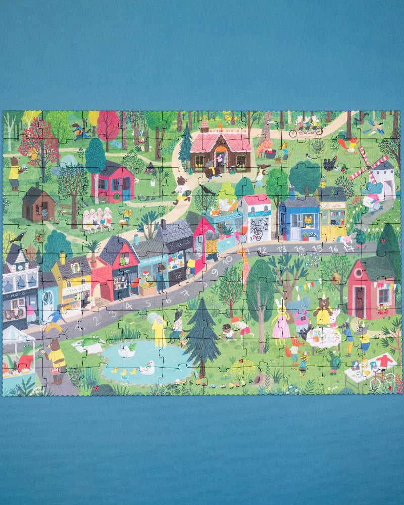 Colorful children's puzzle of a village scene on a blue background