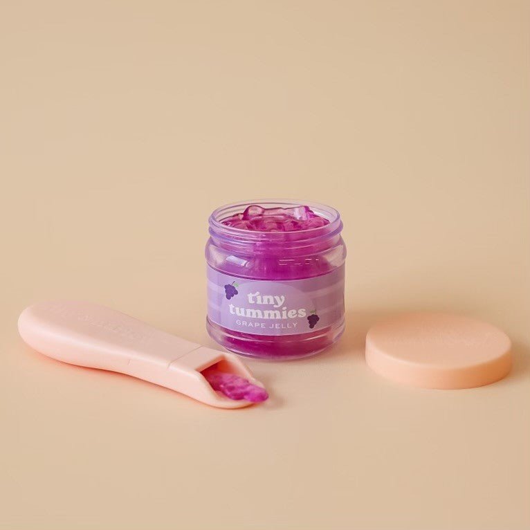 Realistic play kitchen food featuring Tiny Harlow grape jelly doll jar with feeding spoon