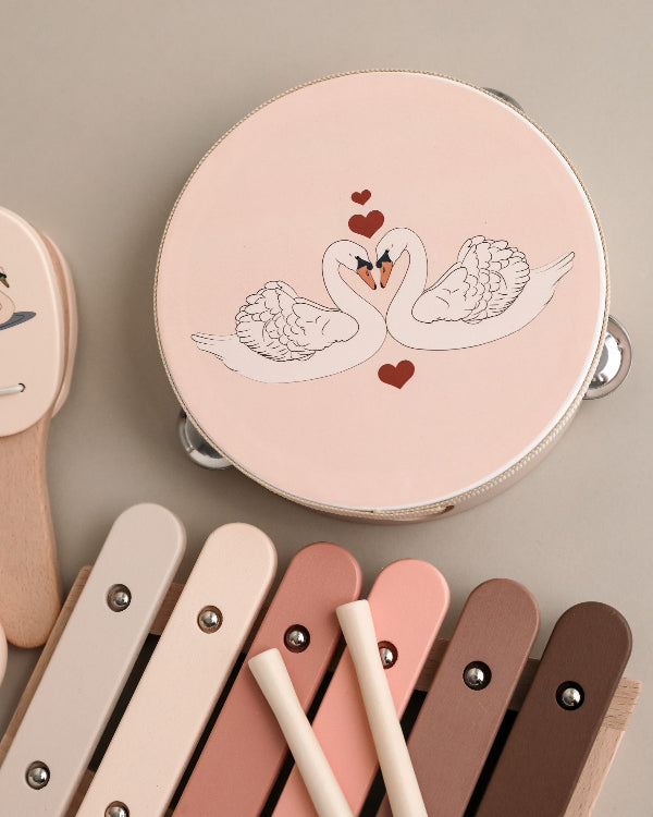 Complete wooden music play set with graceful swan motifs and soft pink finish perfect for children