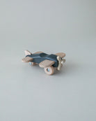 Handcrafted wooden plane in blue finish showing natural wood grain and authentic aviation details