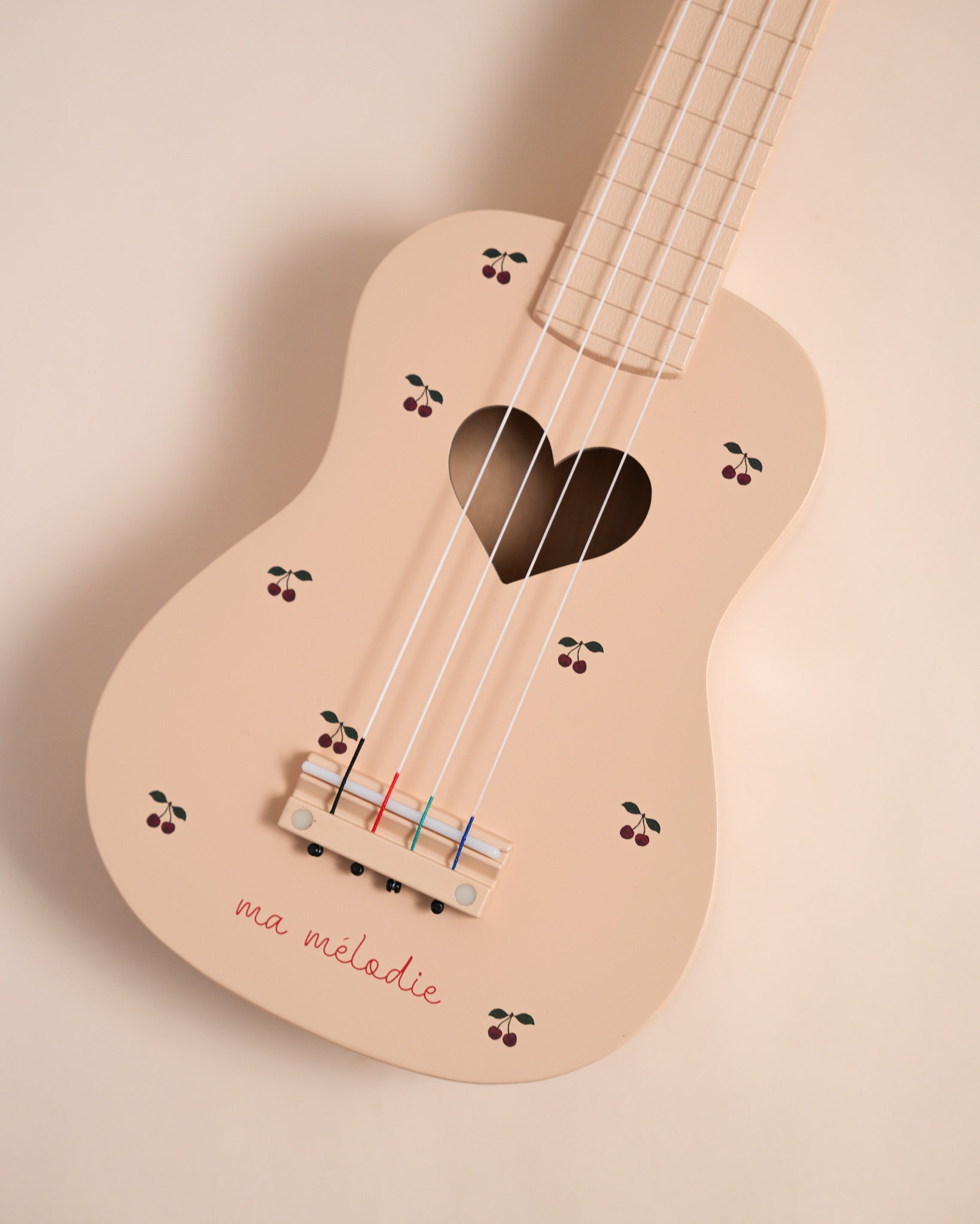 FSC-certified wooden kids ukulele showing hand-painted cherry motifs and ma melodie script detail