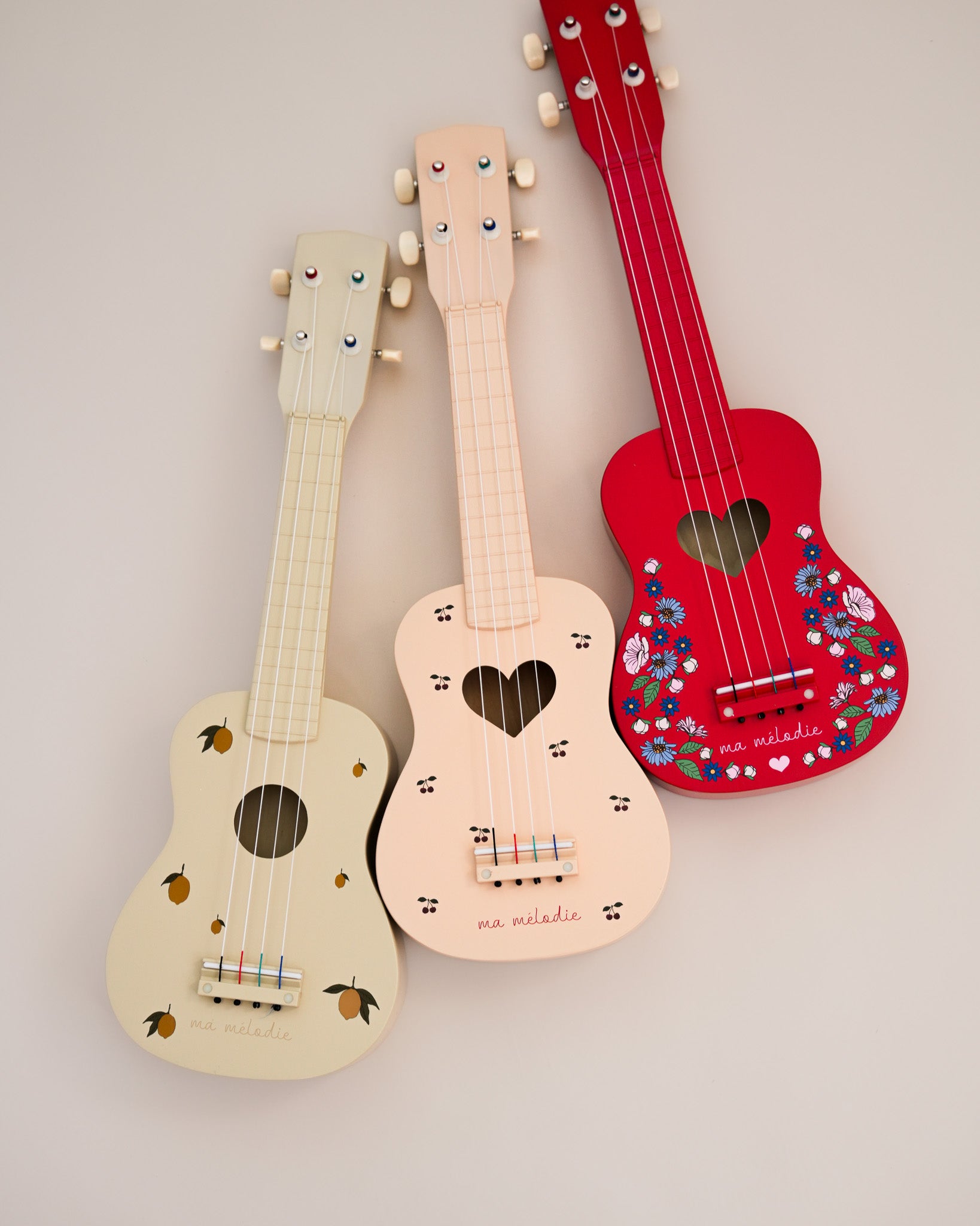 Child-sized wooden ukulele with tunable pegs and blush pink finish perfect for little hands