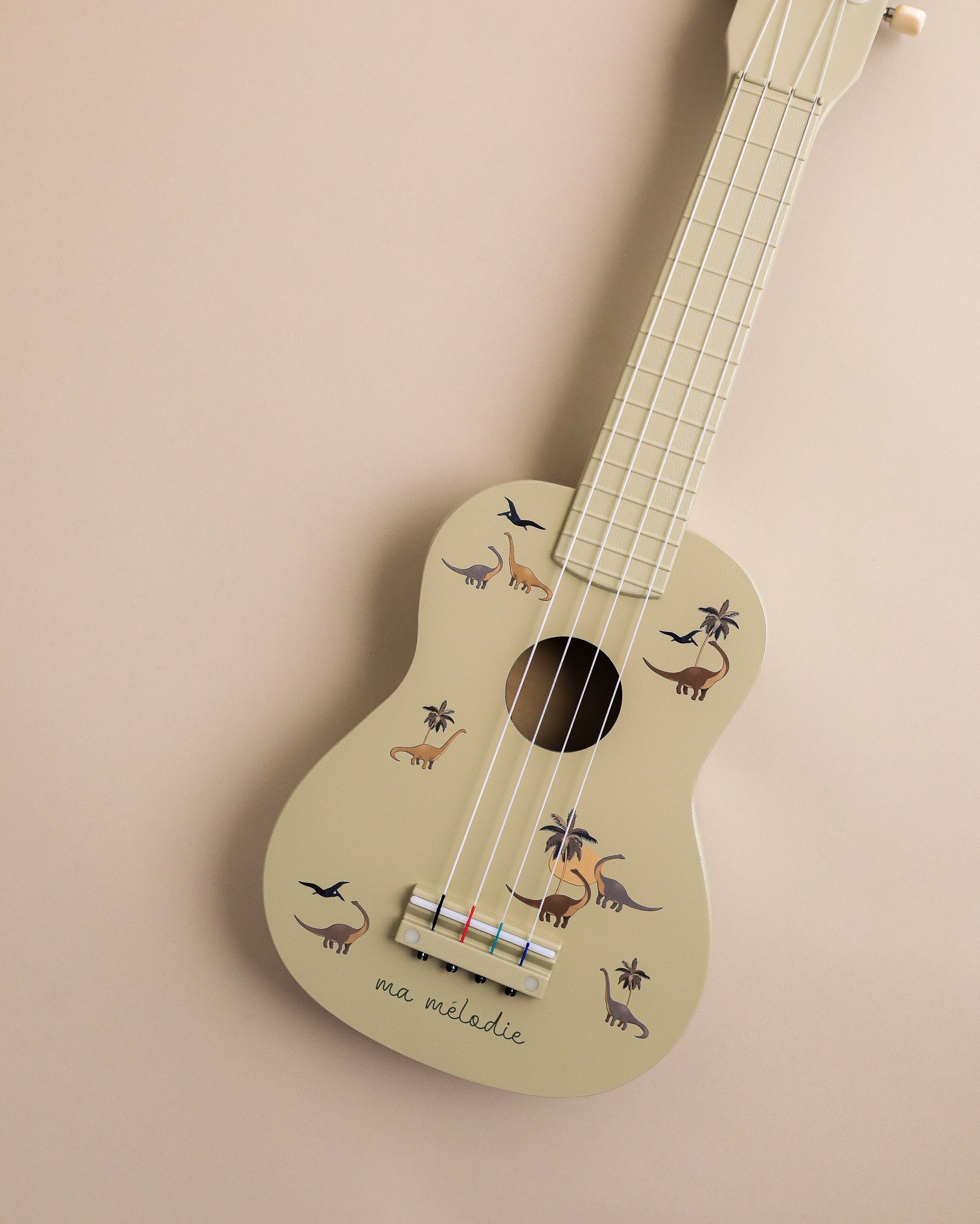 FSC-certified kids ukulele featuring hand-painted dinosaur motifs and ma melodie script detail
