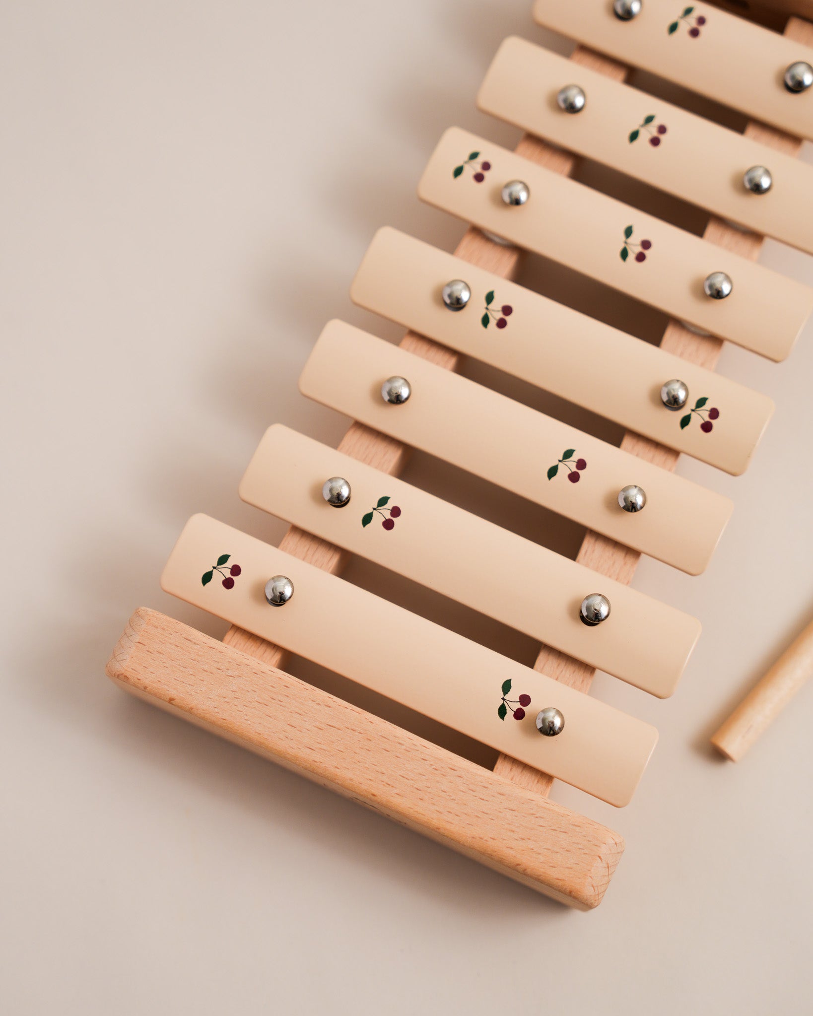 Close-up of hand-painted cherry motifs on wooden xylophone showing artisan craftsmanship details
