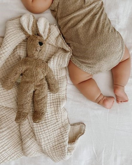 Child carrying Senger Naturwelt beige rabbit toy showing size and scale