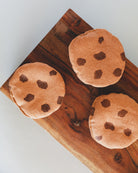 Three handcrafted Danish chocolate chip cookie play food pieces with silk screen printing on wooden board