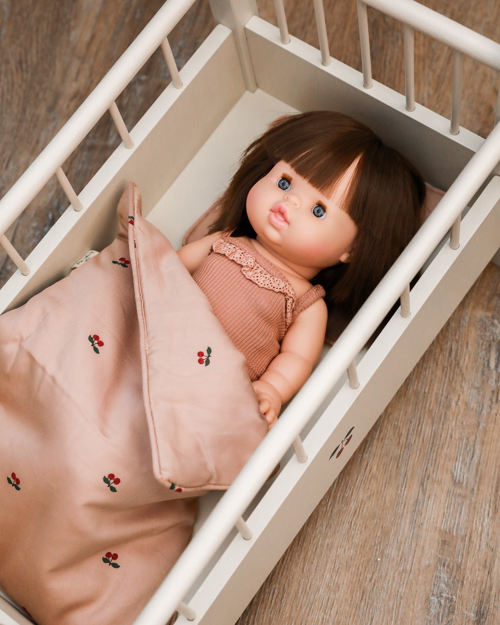 Playroom-quality miniature bedding set with detailed doll pillow and blanket