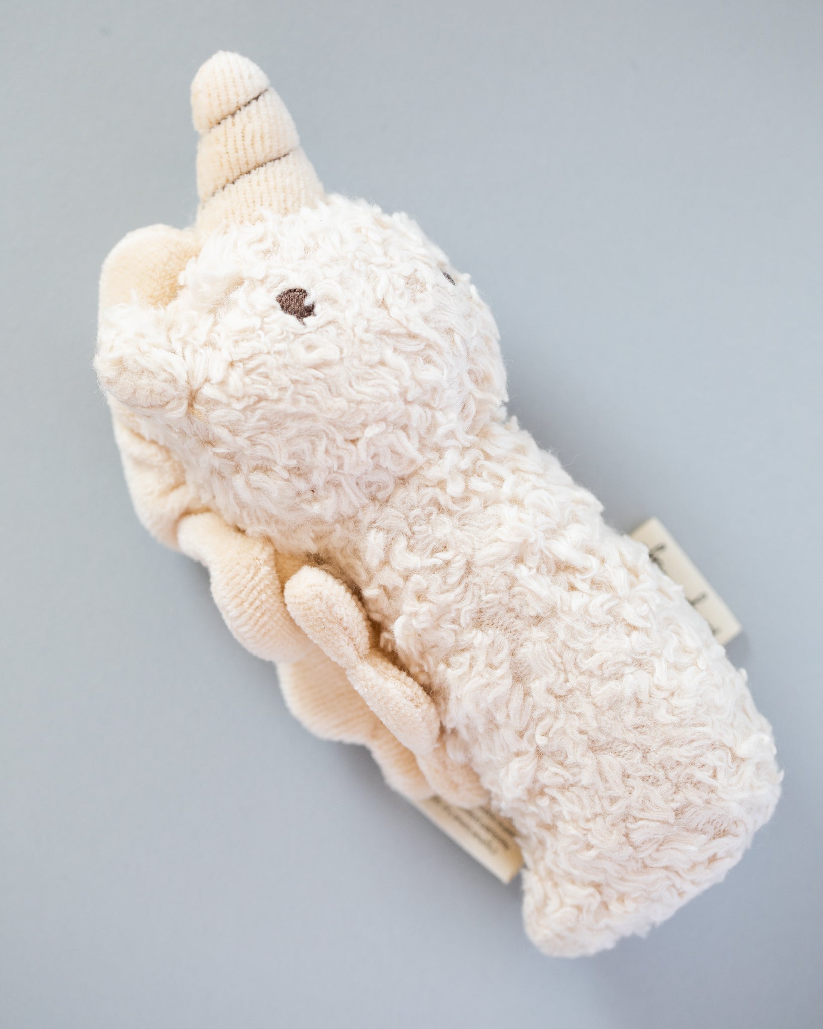 Close-up of soft sherpa fabric texture on mini unicorn rattle showing premium material quality