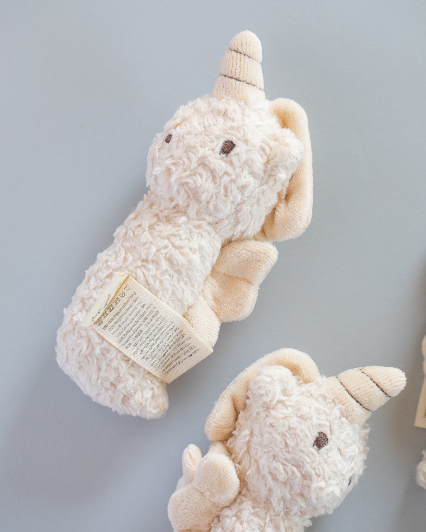 Mini unicorn rattle in nursery setting showing stylish cream color coordination with decor