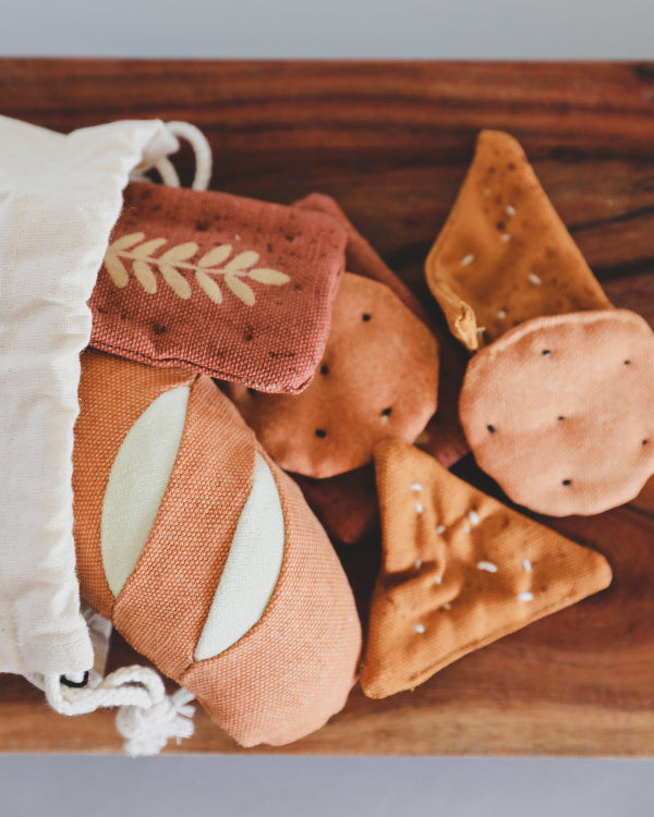 Premium textile play food set showing authentic bread and cracker designs with cotton storage bag
