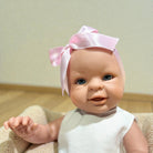 Girl Bebenita doll with blue eyes in pink dress and white ribbed top with ribbon