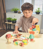 Child playing with wooden toys on a table in a room with plants and furniture.