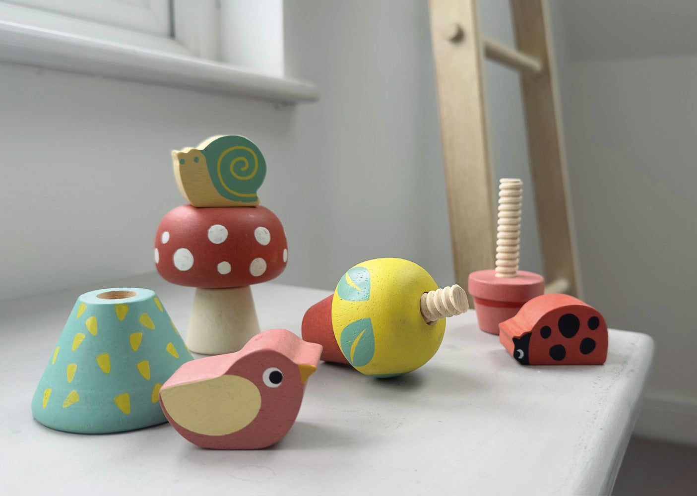 Set of colorful wooden toys on a white surface with a blurred background