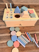 Collection of pastel colored wooden shapes included with Montessori multi-activity sorting box