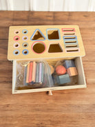 Close-up of wooden shape sorter showing precise craftsmanship and color-coded openings