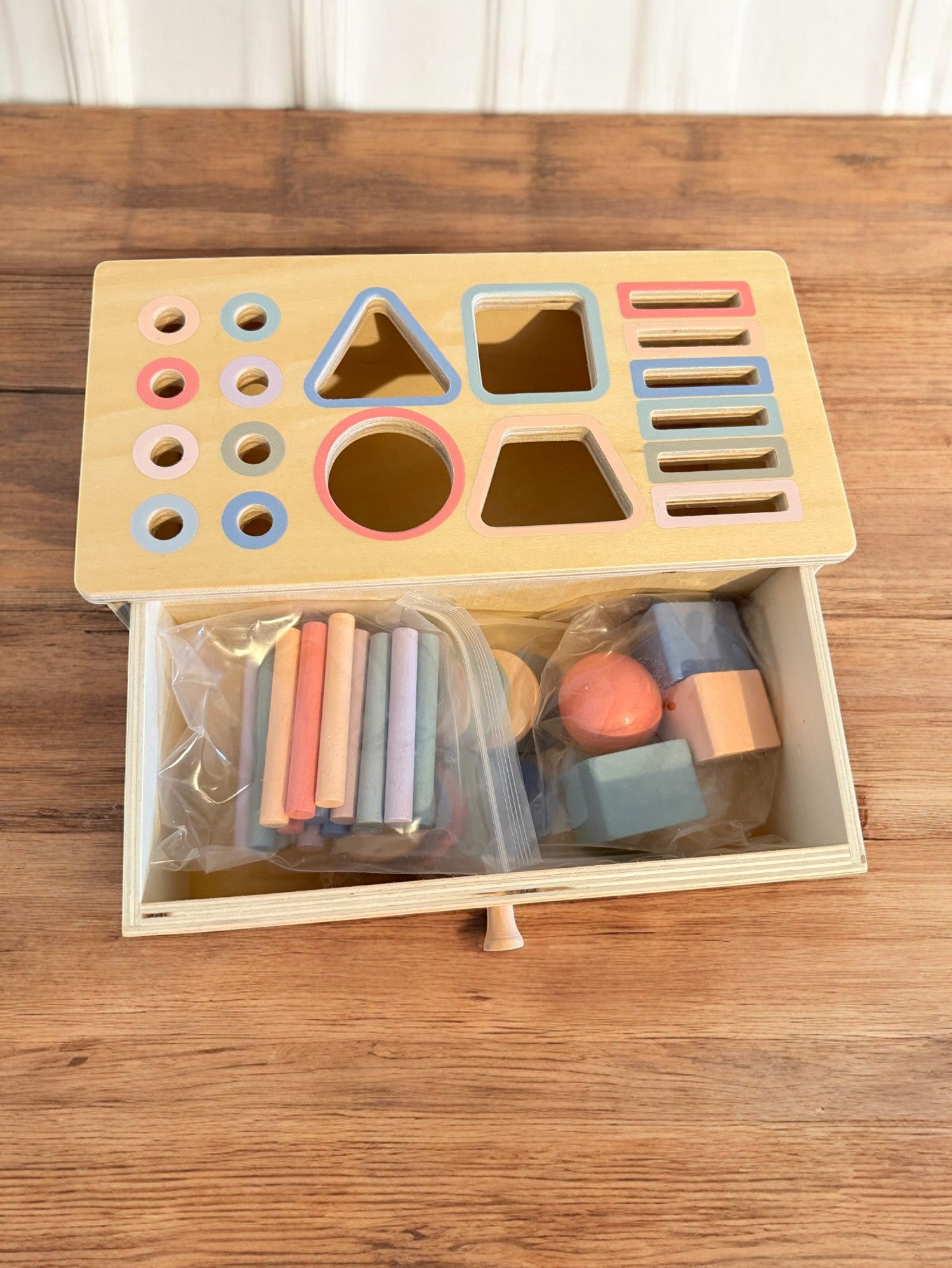 Close-up of wooden shape sorter showing precise craftsmanship and color-coded openings
