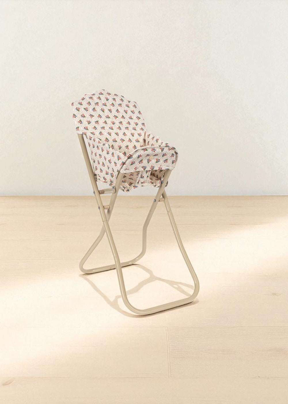 Cream-colored doll feeding chair showing coral and teal rose print with stable base design