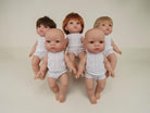 Five dolls in white outfits on a plain background