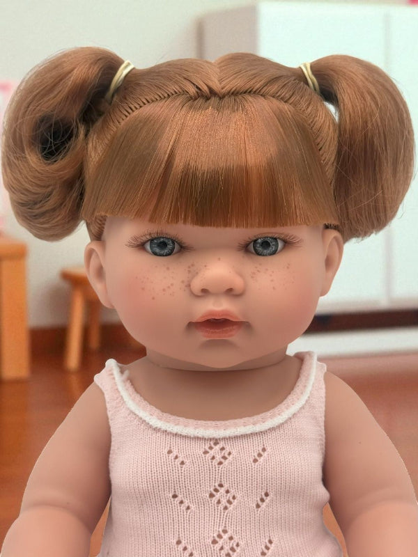 Close-up of Sydney doll's lifelike face with blue eyes and freckles