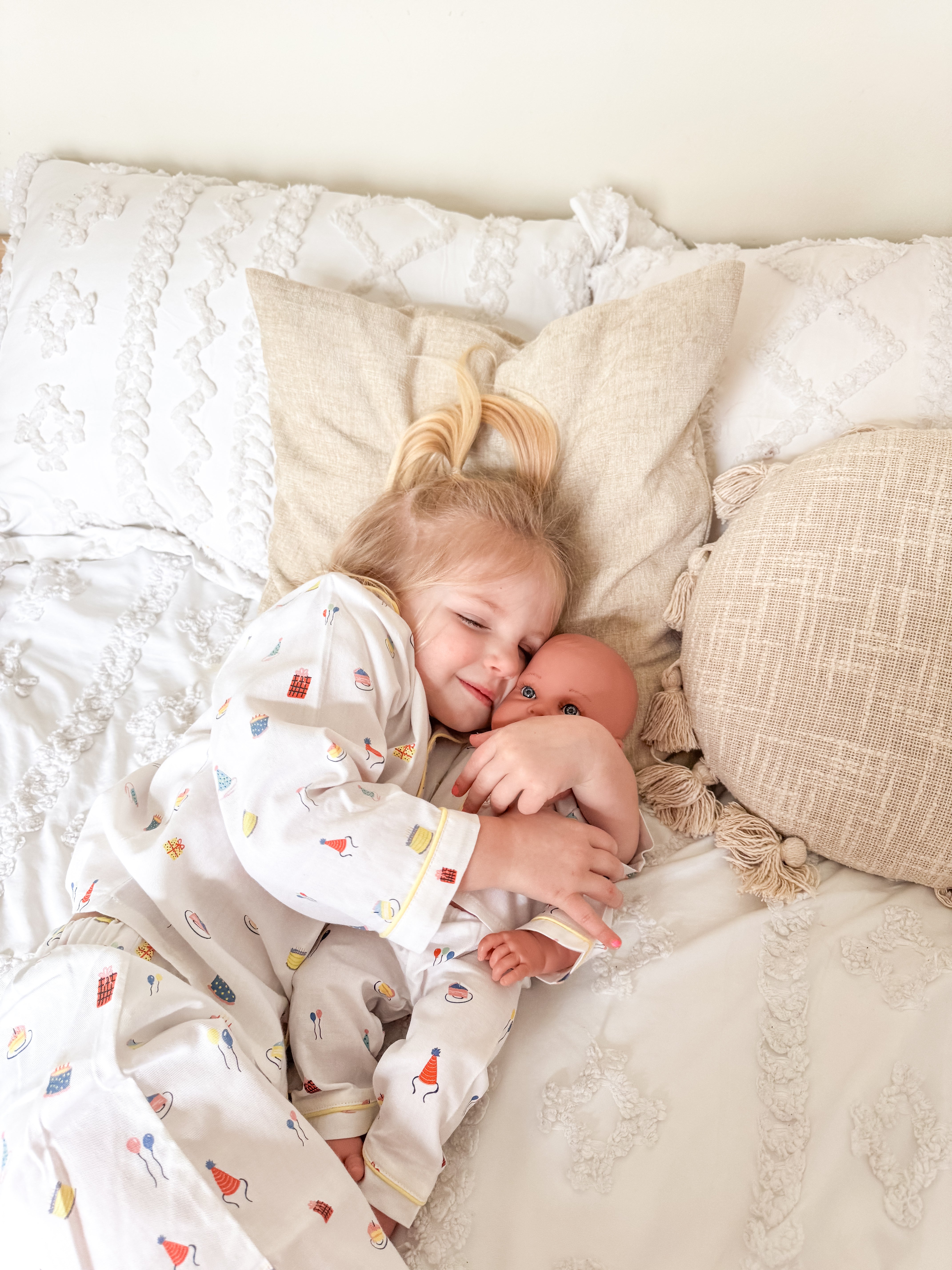 Girl hugging doll in Birthday Pajamas