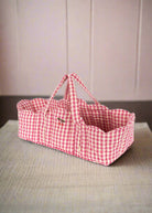 Pink gingham doll bassinet with classic checkered pattern and sturdy carrying handles