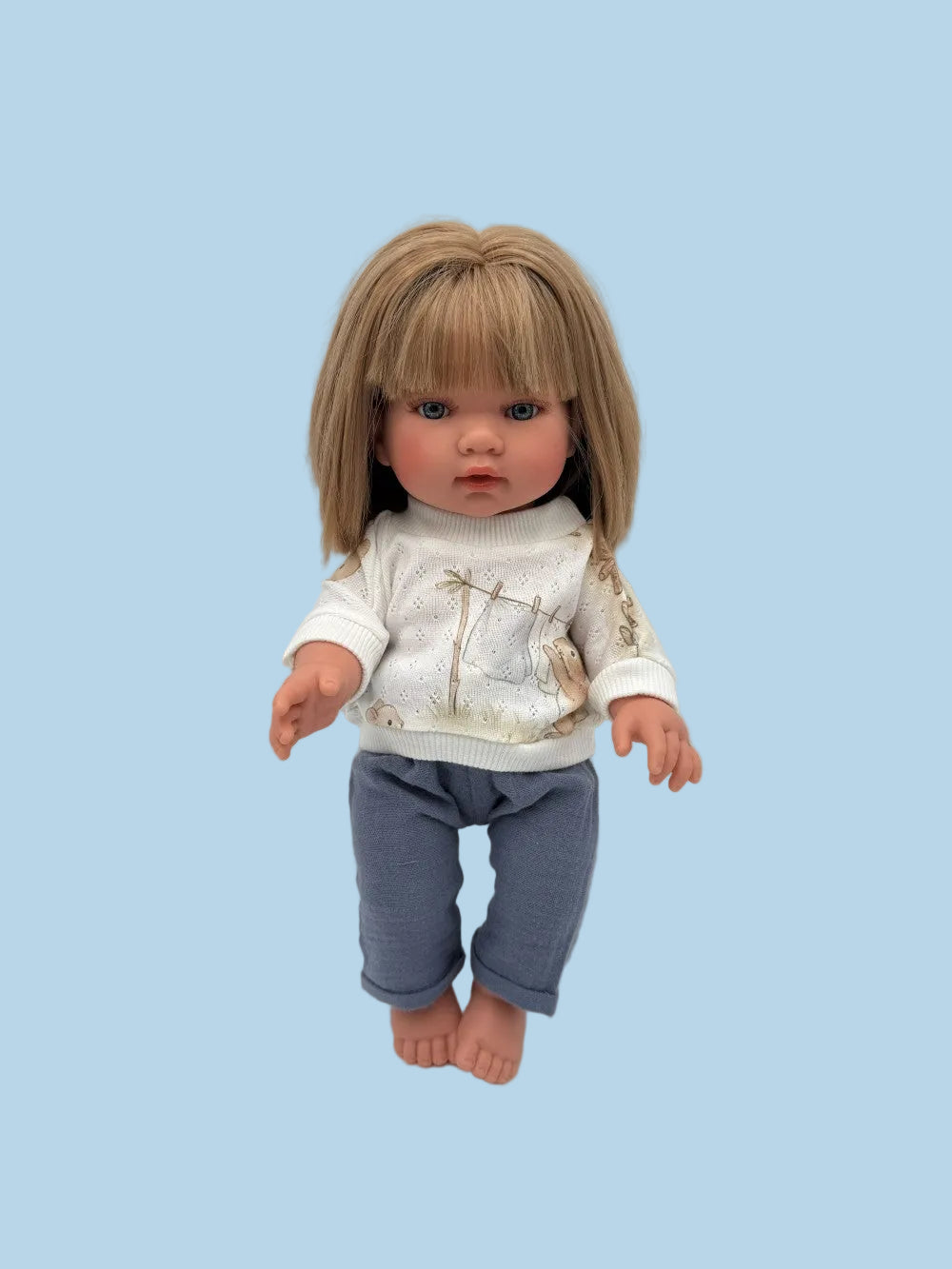 Handmade doll sweater and pants set laid flat, showing bunny print sweater and coordinating pants