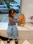 Child tucking in doll in the little carrier