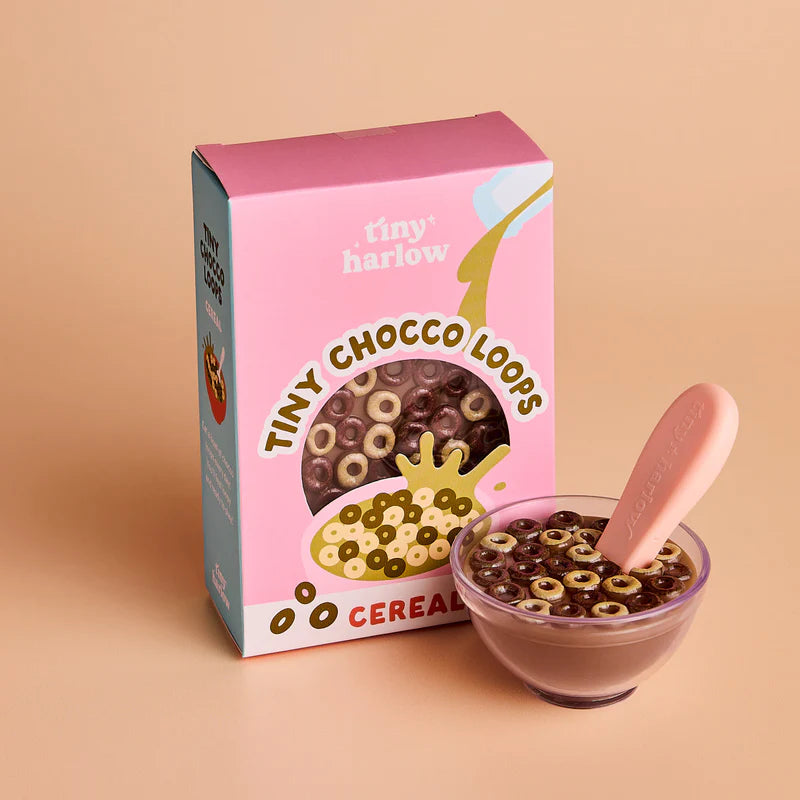 Tiny Harlow cereal box with a bowl of cereal and spoon on a beige background