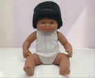 Doll with black hair wearing a white lace outfit on a white background