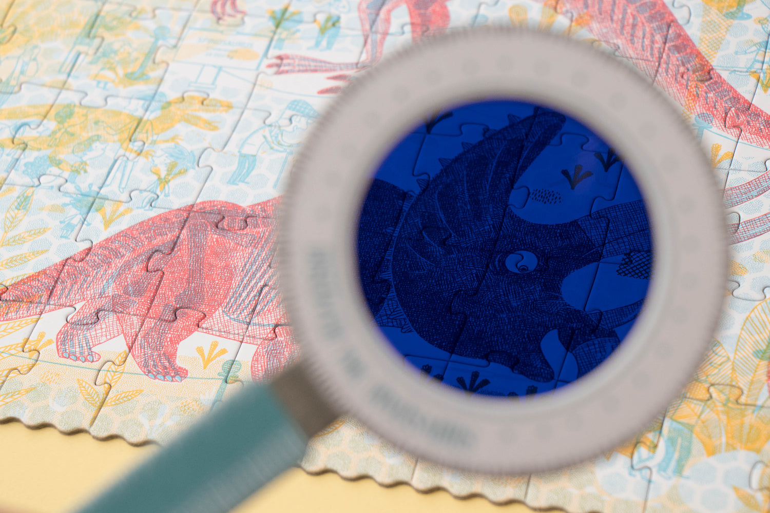 Magnifying glass over a colorful puzzle with a blue section