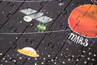 Space-themed puzzle with illustrations of a spacecraft, alien, and UFO on a black background with white dots.