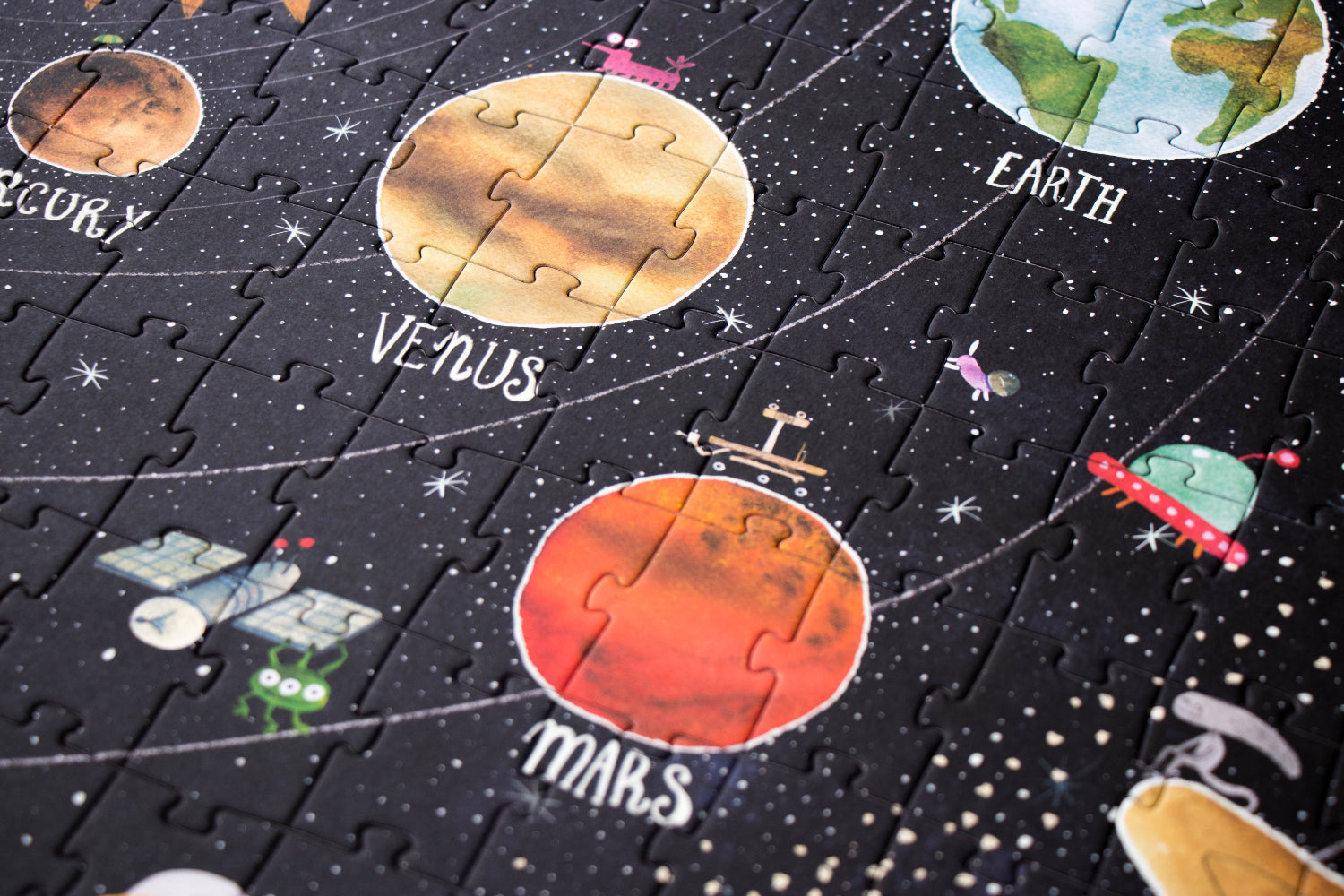 Solar system-themed puzzle with planets and astronauts on a black background