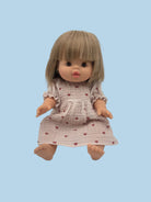 Doll wearing soft cotton muslin dress in mauve heart pattern matching Leni & Romi collection