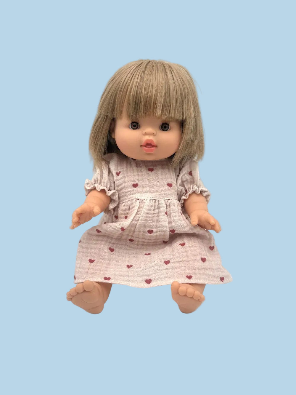 Doll with a dress featuring heart patterns on a light blue background