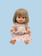 Doll with a dress featuring heart patterns on a light blue background