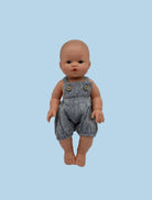 Bebenita doll wearing handmade chambray muslin overall with functional buttons, standing against white background