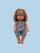Doll wearing a denim overalls with a plain background