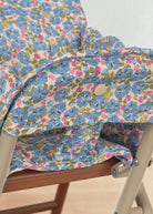 Close-up of quilted Fleur Rosier print cushion showing cornflower blue flowers with pink accents and green leaves on cream background
