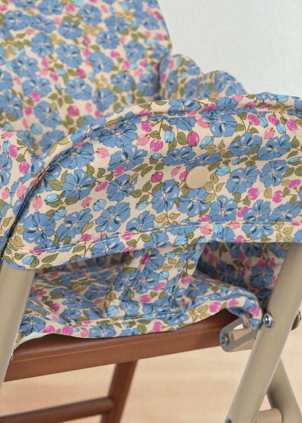 Close-up of quilted Fleur Rosier print cushion showing cornflower blue flowers with pink accents and green leaves on cream background