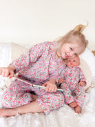 Girl and doll wearing floral pjs