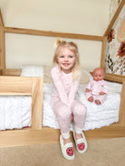 Girl and doll in pink pajamas