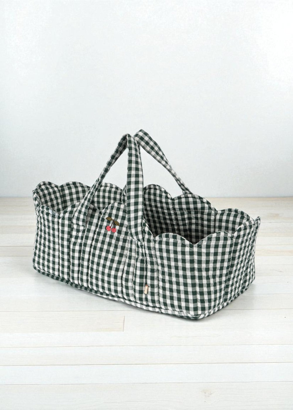 Green check doll bassinet with classic gingham pattern, sturdy handles and soft cotton interior lining