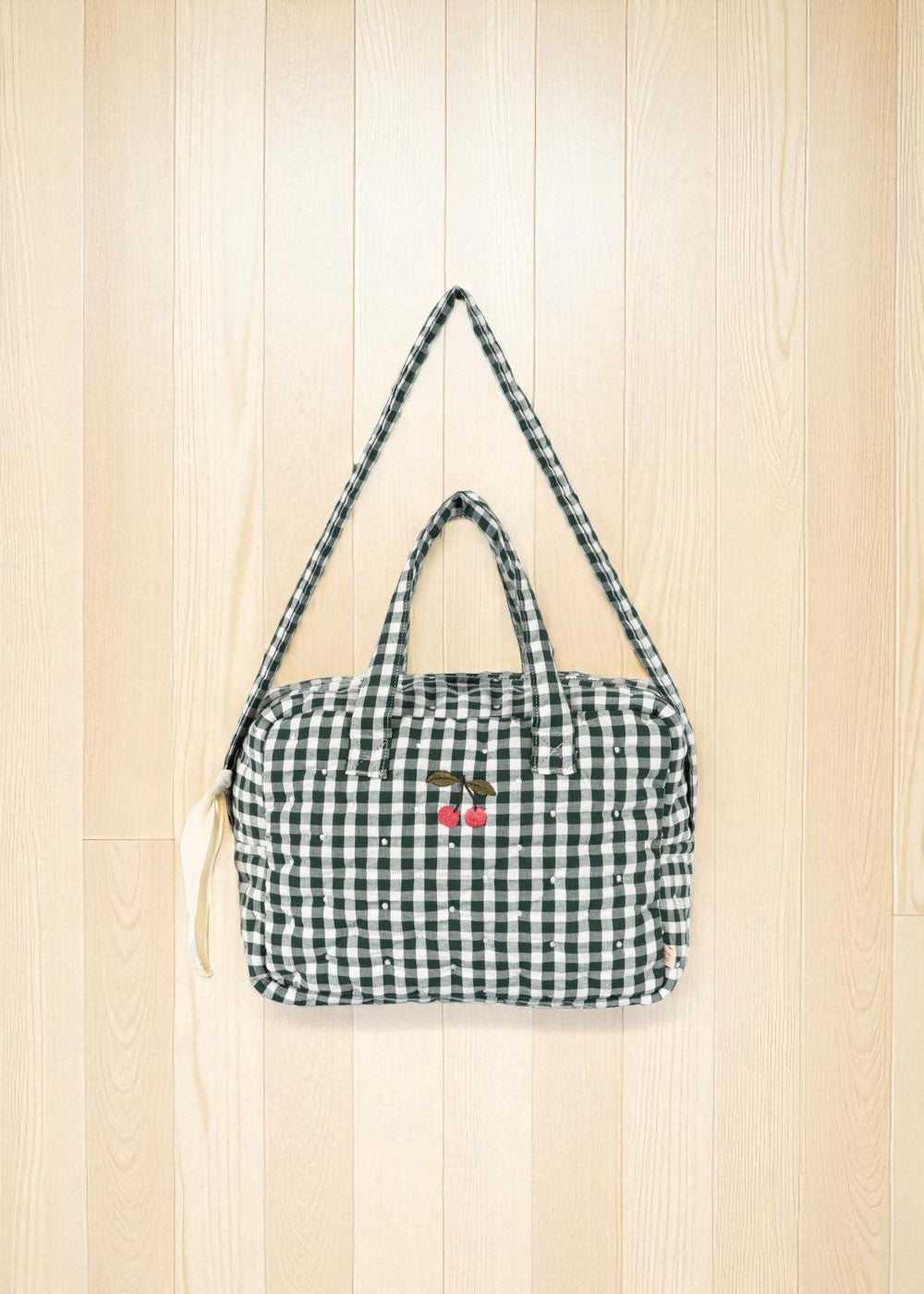 Front view of green and white checkered doll bag with cherry embroidery detail