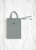 Premium construction detail showing button-tufted craftsmanship of green check doll bedding set