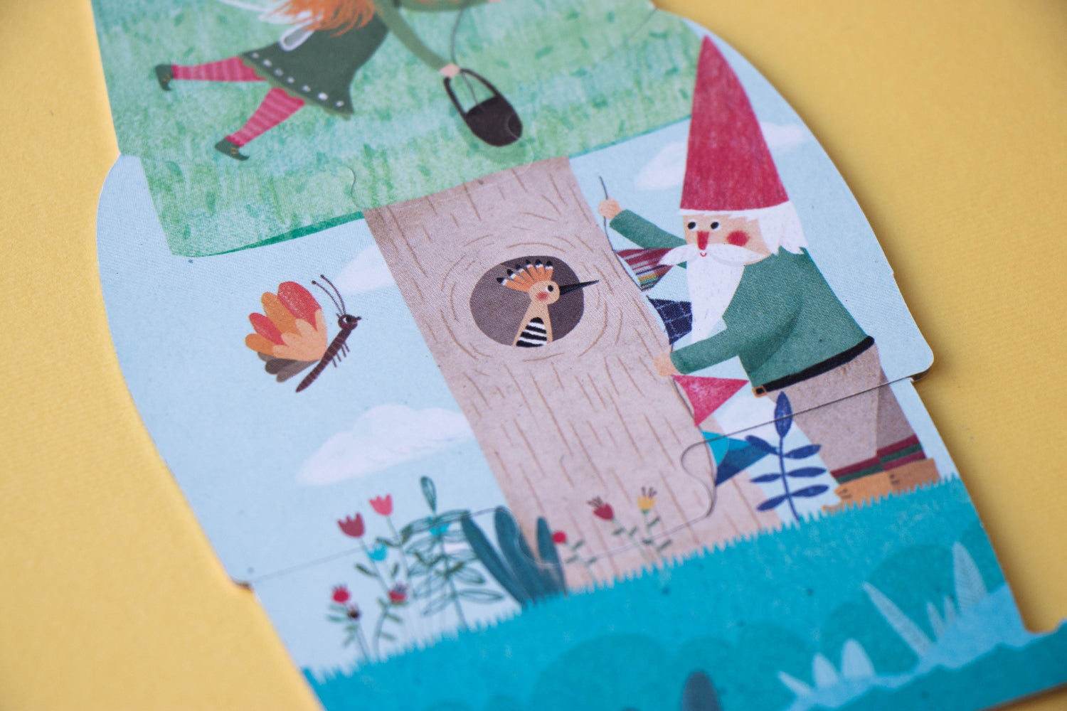 Children's book with illustrations of a gnome, flowers, and a castle on a yellow background