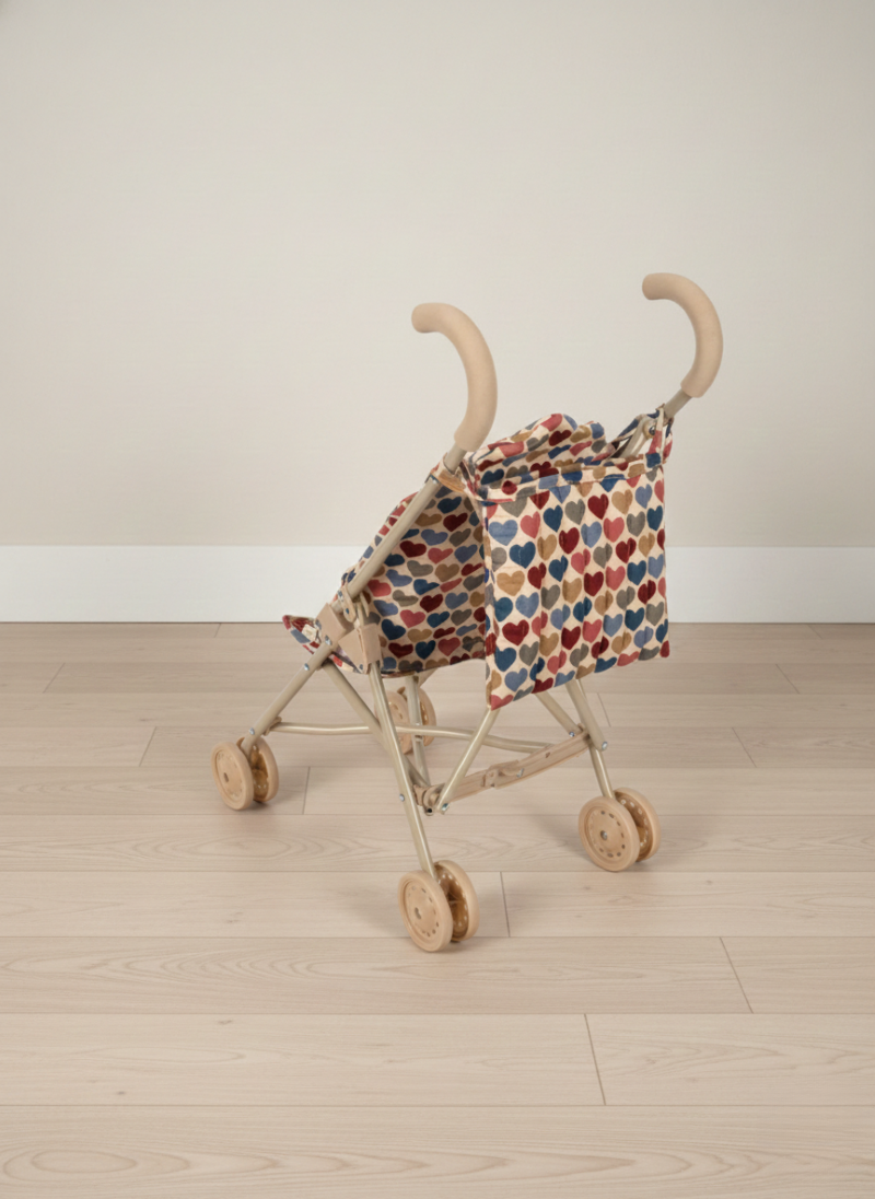 Doll stroller with a patterned cover on a wooden floor