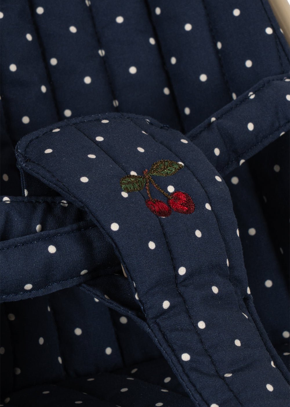 Navy blue fabric with white polka dots and a cherry embroidery detail.