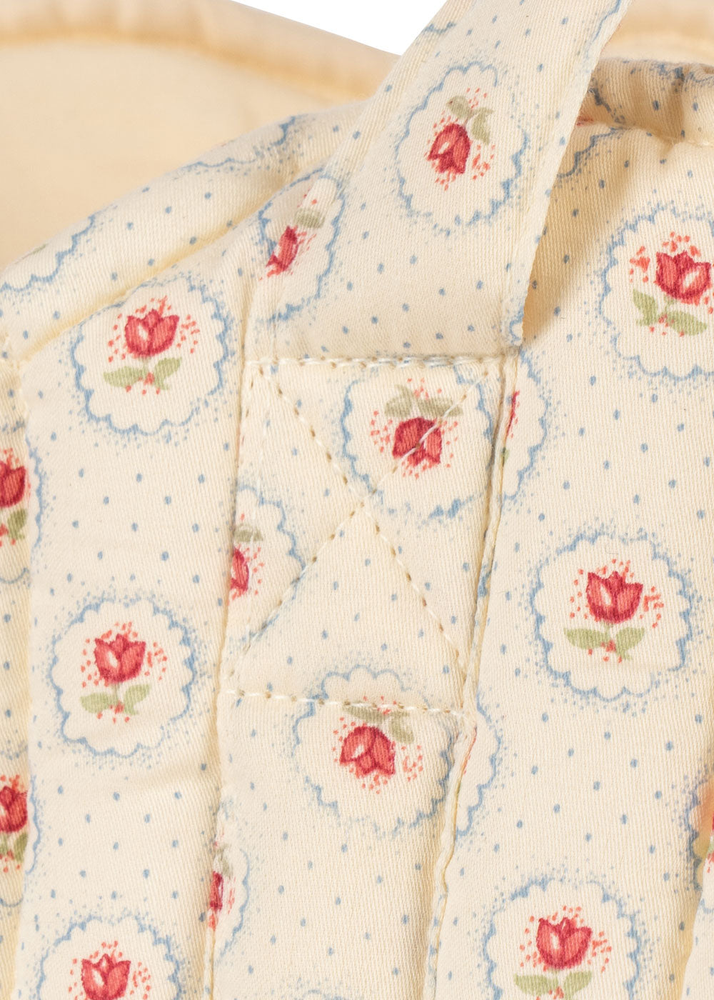 OEKO-TEX cotton bassinet showing cream fabric with botanical tulip pattern blue trim