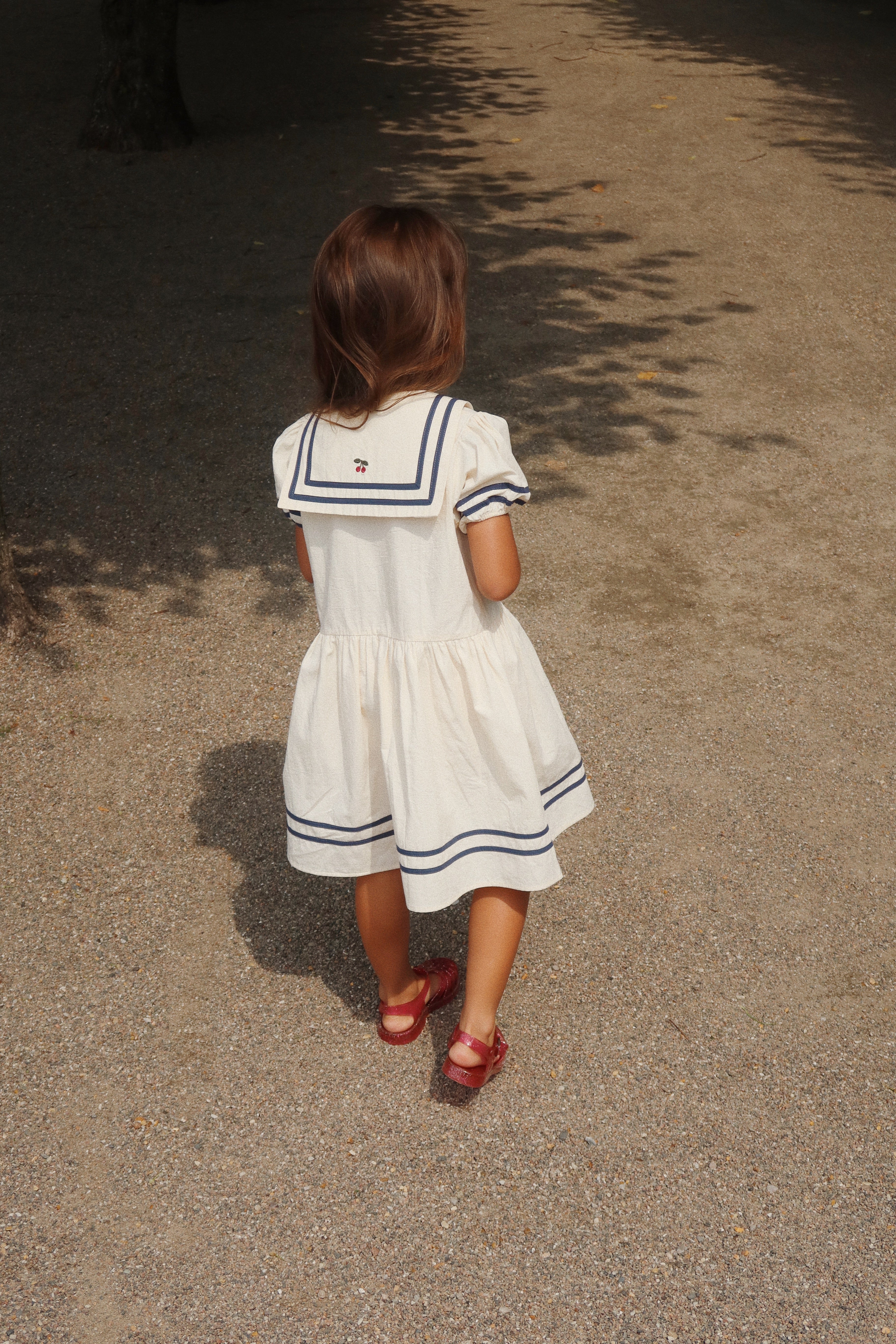 Allie Sailor Dress: Organic Cotton Nautical Design with Cherry Detail – Playroom Collective Allie Sailor Dress: Organic Cotton Nautical Design with Cherry Detail – Playroom Collective